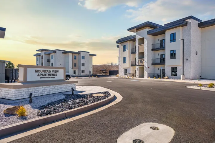 Contemporary apartment buildings featuring light-colored brick and stucco exteriors with dark trim