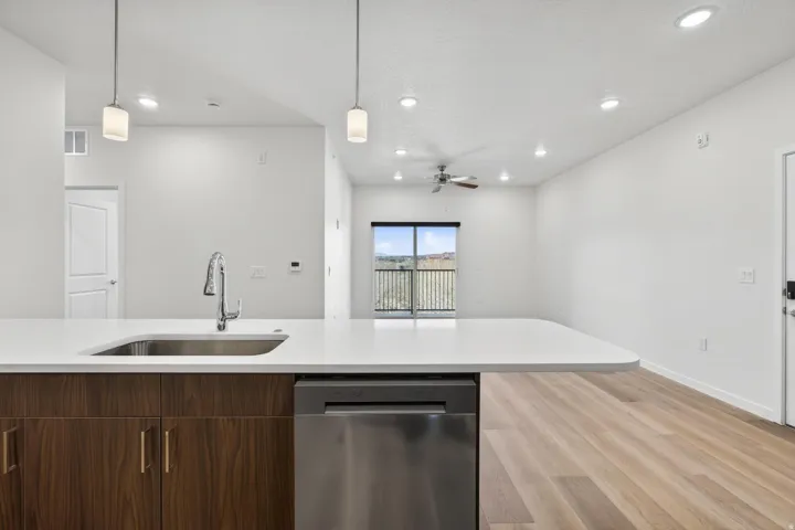 Spacious kitchen island with a stainless steel sink, contemporary faucet, and integrated dishwasher