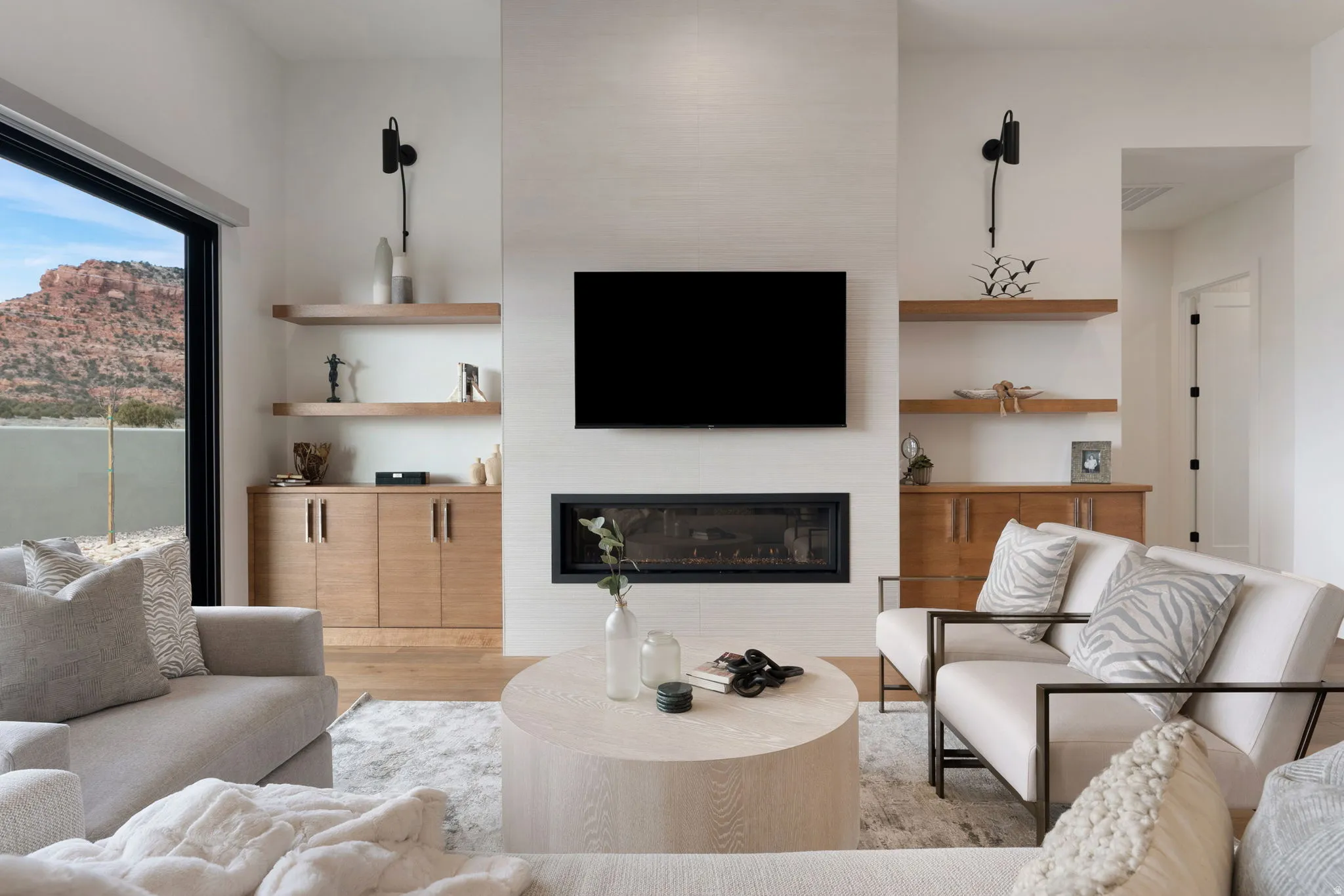 Modern living space featuring a wall-mounted linear fireplace with a textured surround