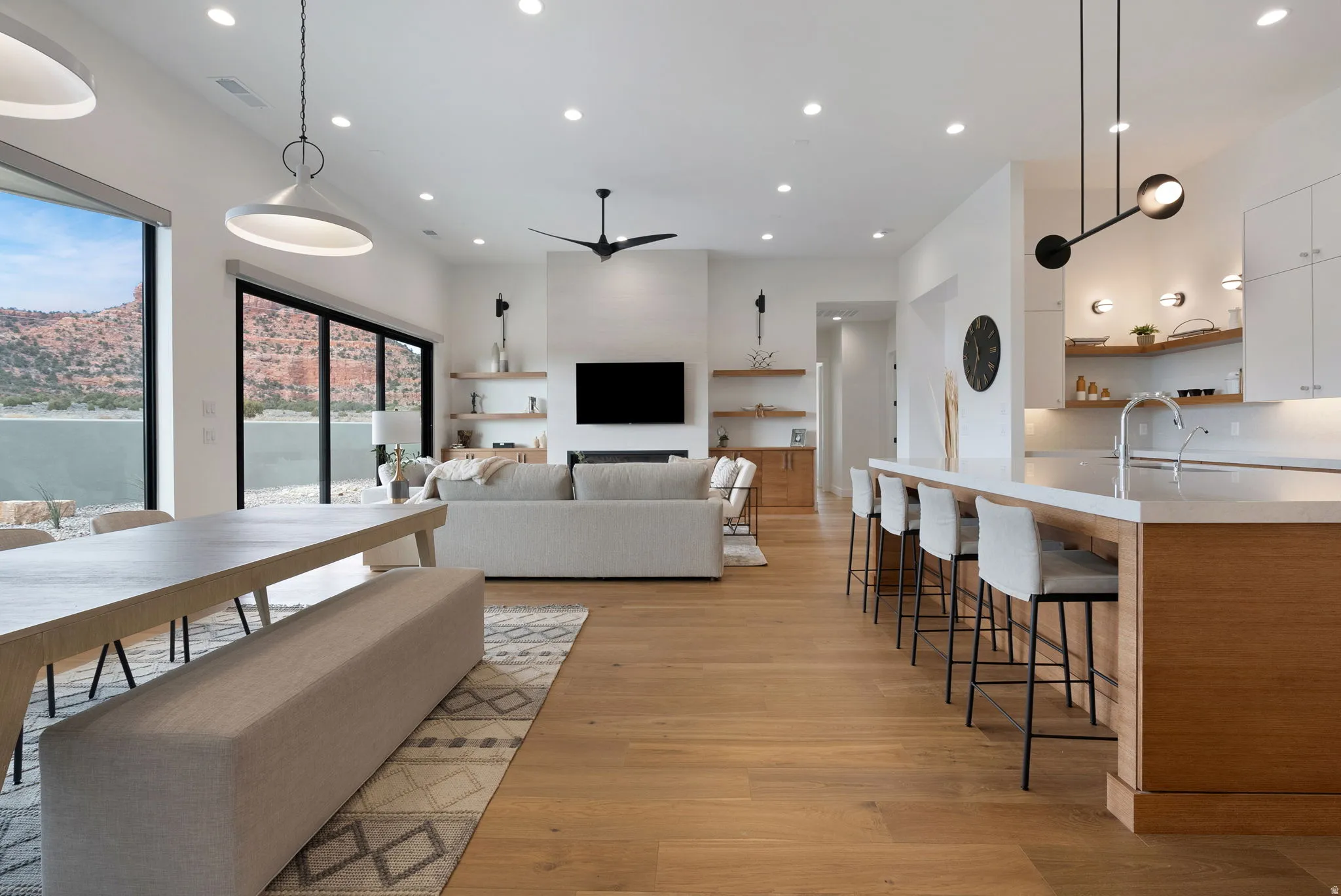Open-concept living space featuring wood-finish flooring, recessed lighting, and a white color palette