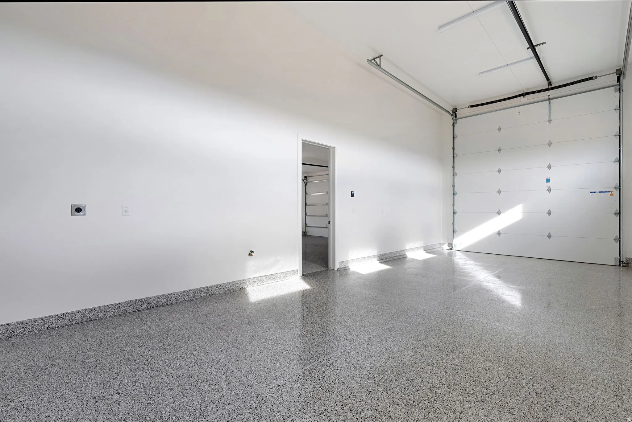 Spacious interior with an epoxy-coated flooring system and a roll-up garage door