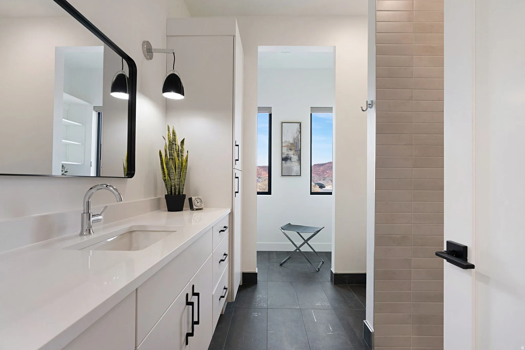 Bathroom vanity featuring a polished chrome faucet, integrated rectangular sink, and white countertop