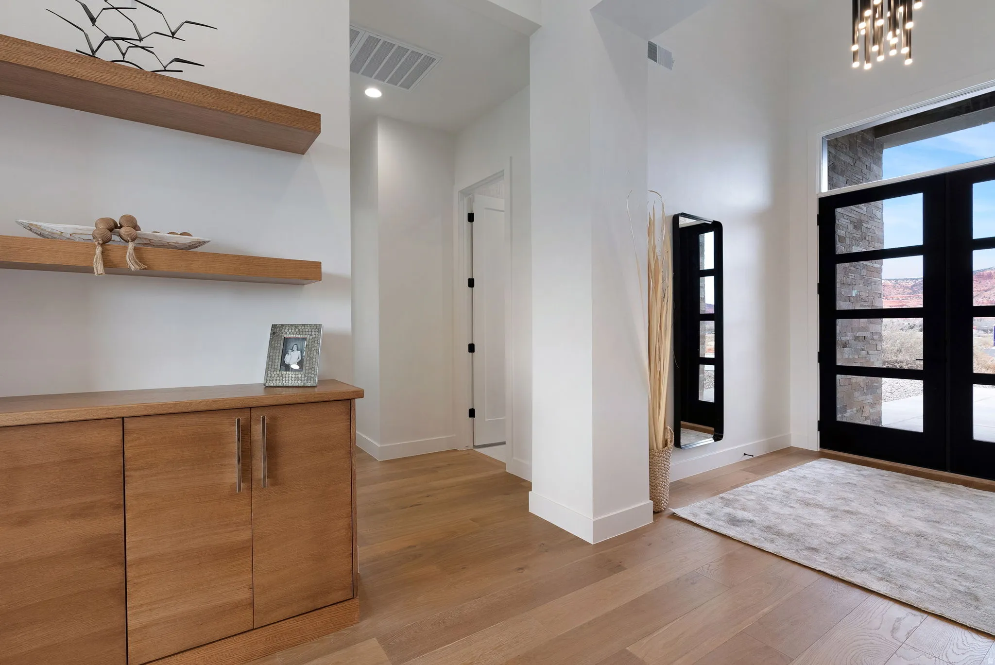 Entryway featuring a double door with multiple glass panes, a transom window, and a contemporary chandelier