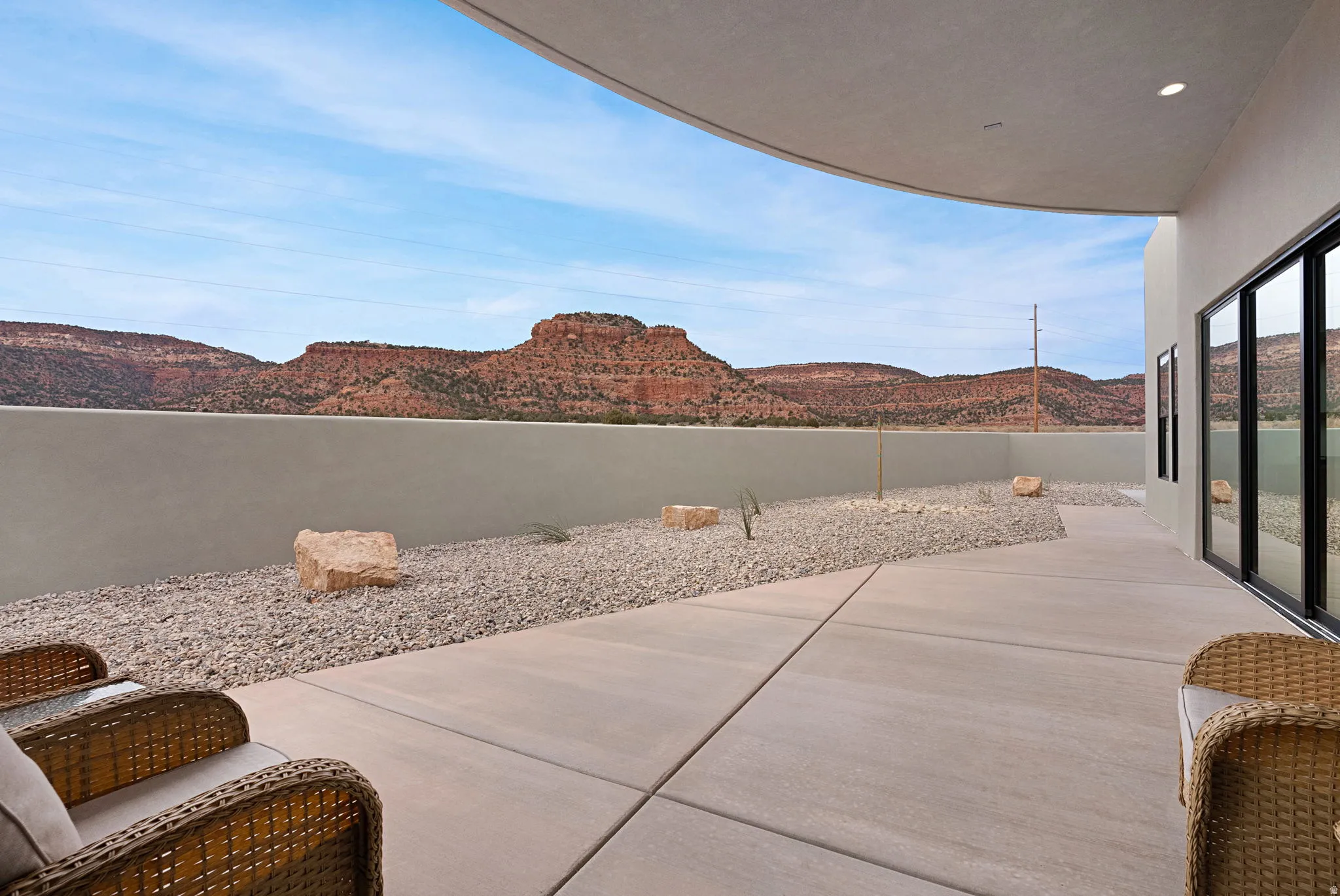 Expansive outdoor patio with concrete paving and gravel landscaping