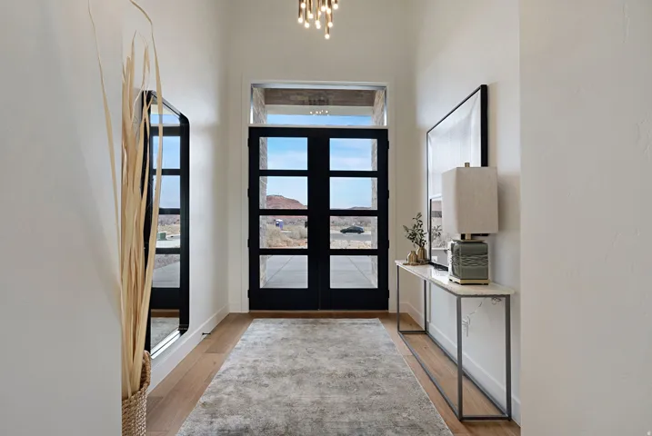 Entryway featuring a pair of four-pane black doors with transom window
