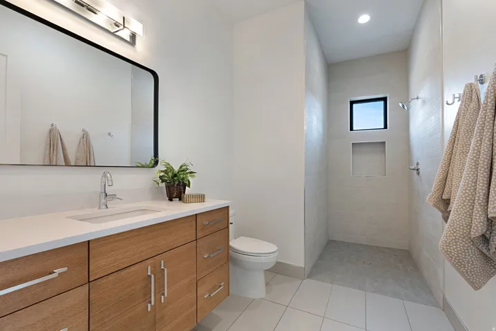 Modern bathroom featuring a wood-finish vanity with an integrated sink and chrome fixtures