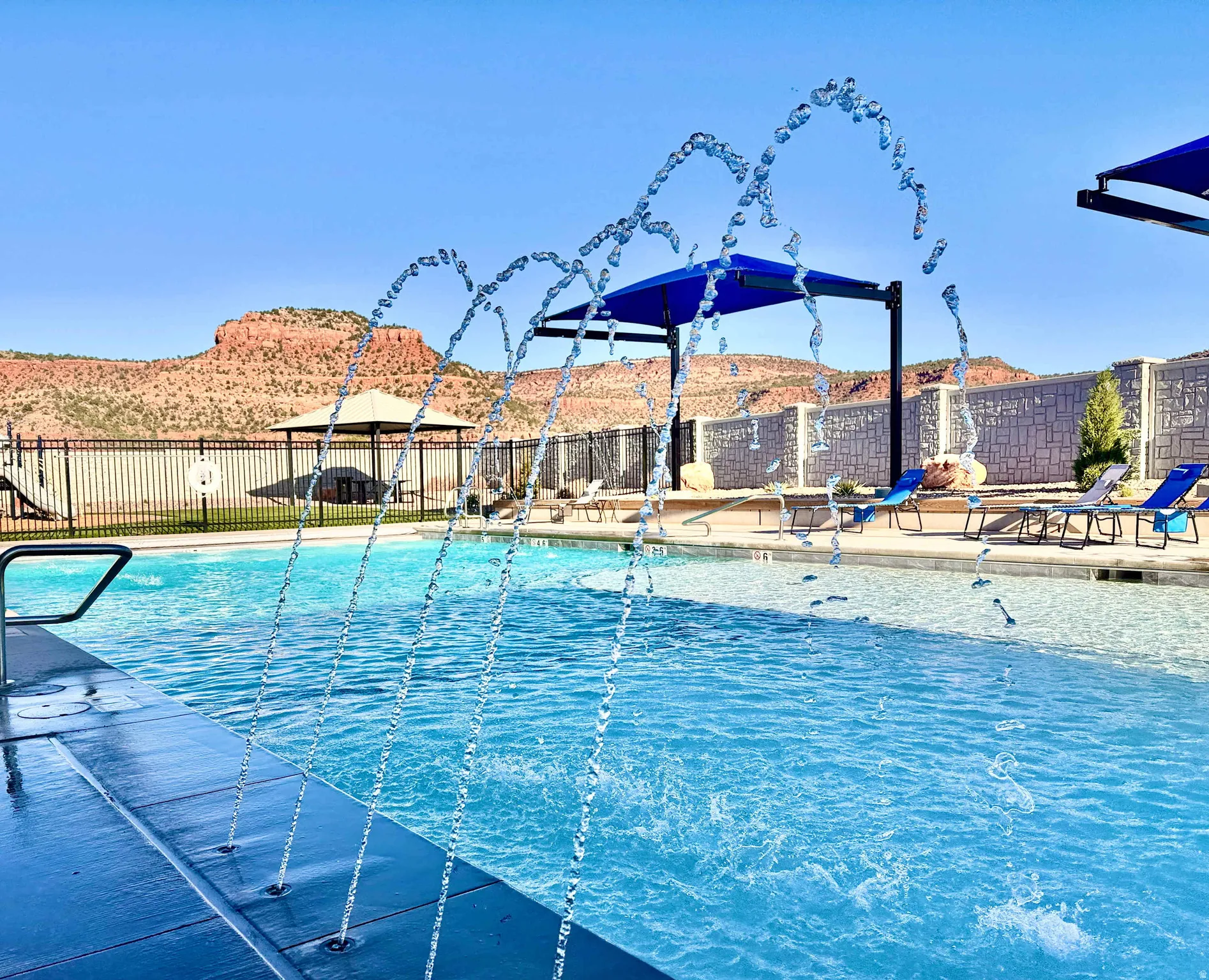 Swimming pool with integrated water features and a baja shelf