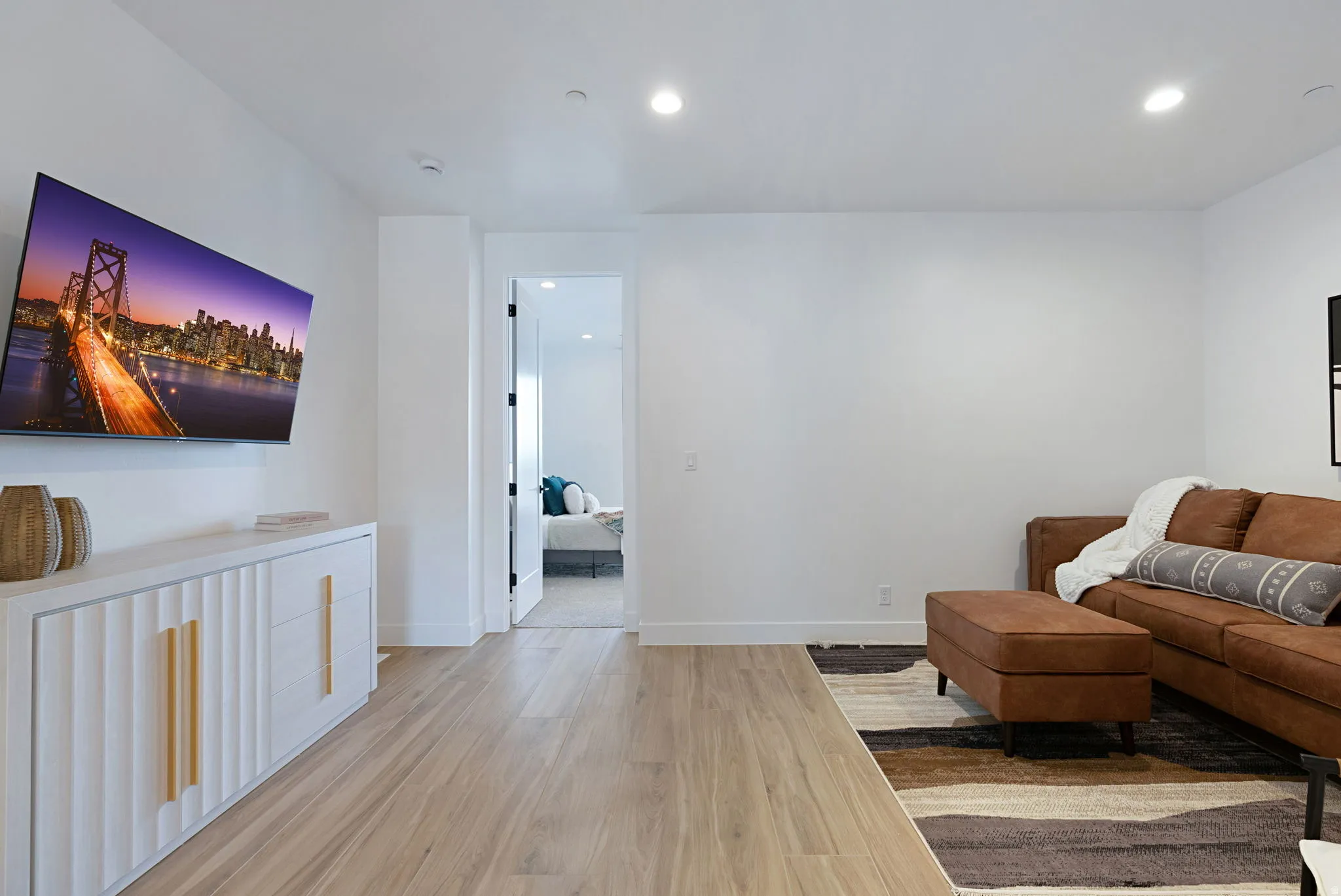 Spacious room featuring light wood-finish flooring, recessed lighting, and white baseboards
