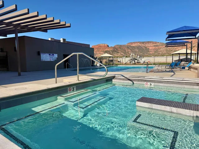 Resort-style pool with integrated steps and a splash pad feature