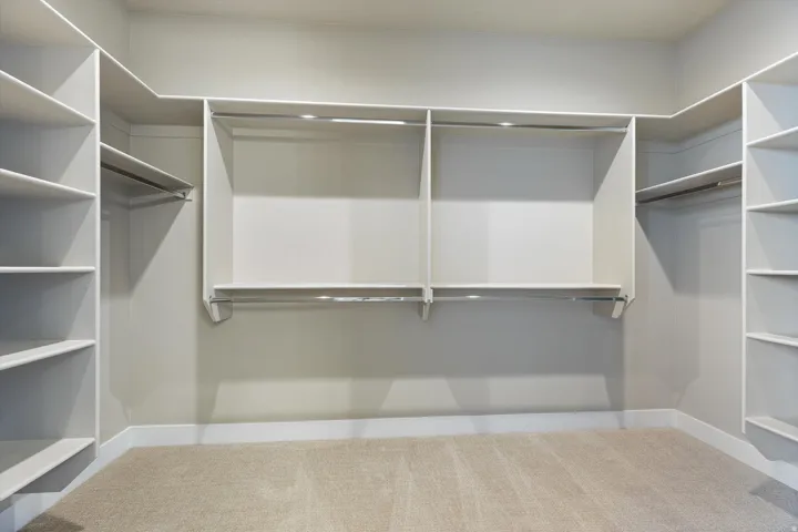 Custom closet system featuring extensive shelving and multiple hanging rods