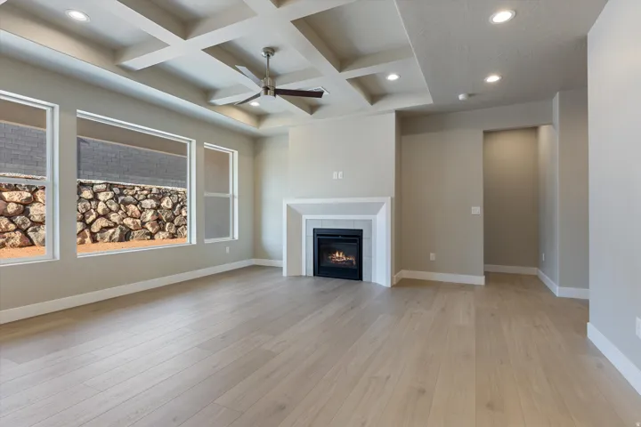 Expansive living area featuring a coffered ceiling with recessed lighting and a ceiling fan