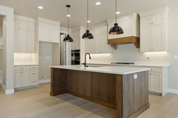 Spacious kitchen featuring an expansive center island with a light-toned wood-finish base and white countertop