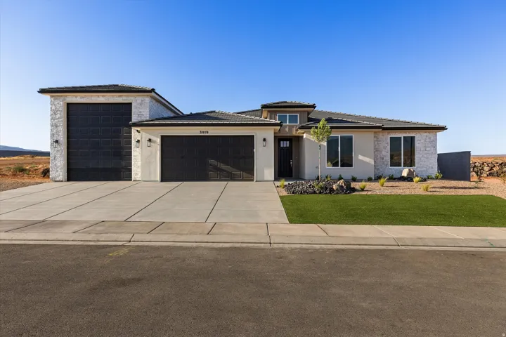 Contemporary exterior featuring light stucco and stone accents