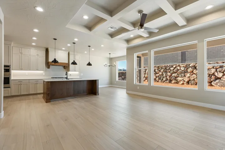 Open-concept living space featuring light wood-finish flooring and a coffered ceiling