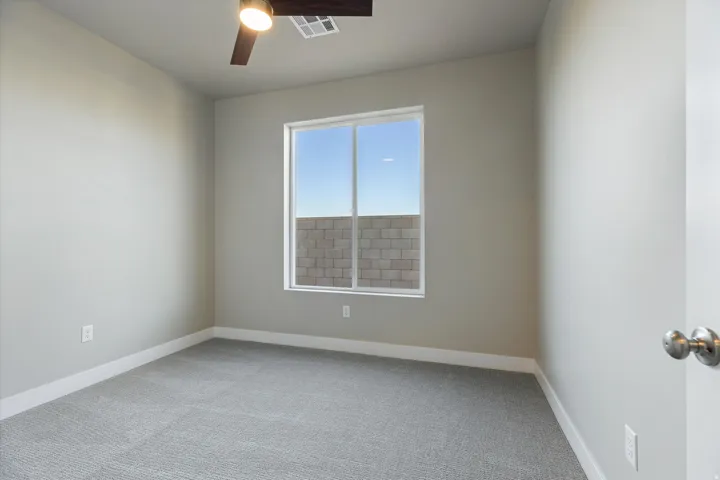Room featuring a window, light gray carpeting, neutral wall paint, white baseboards, and a ceiling fan with light fixture