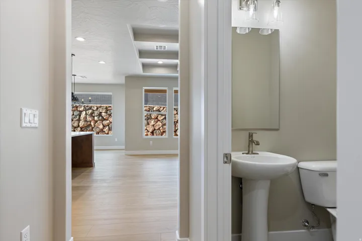 Pedestal sink with a brushed nickel faucet and coordinating vanity light fixture