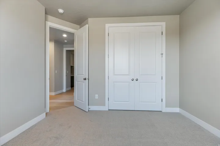 Light-toned carpeted flooring with white baseboards