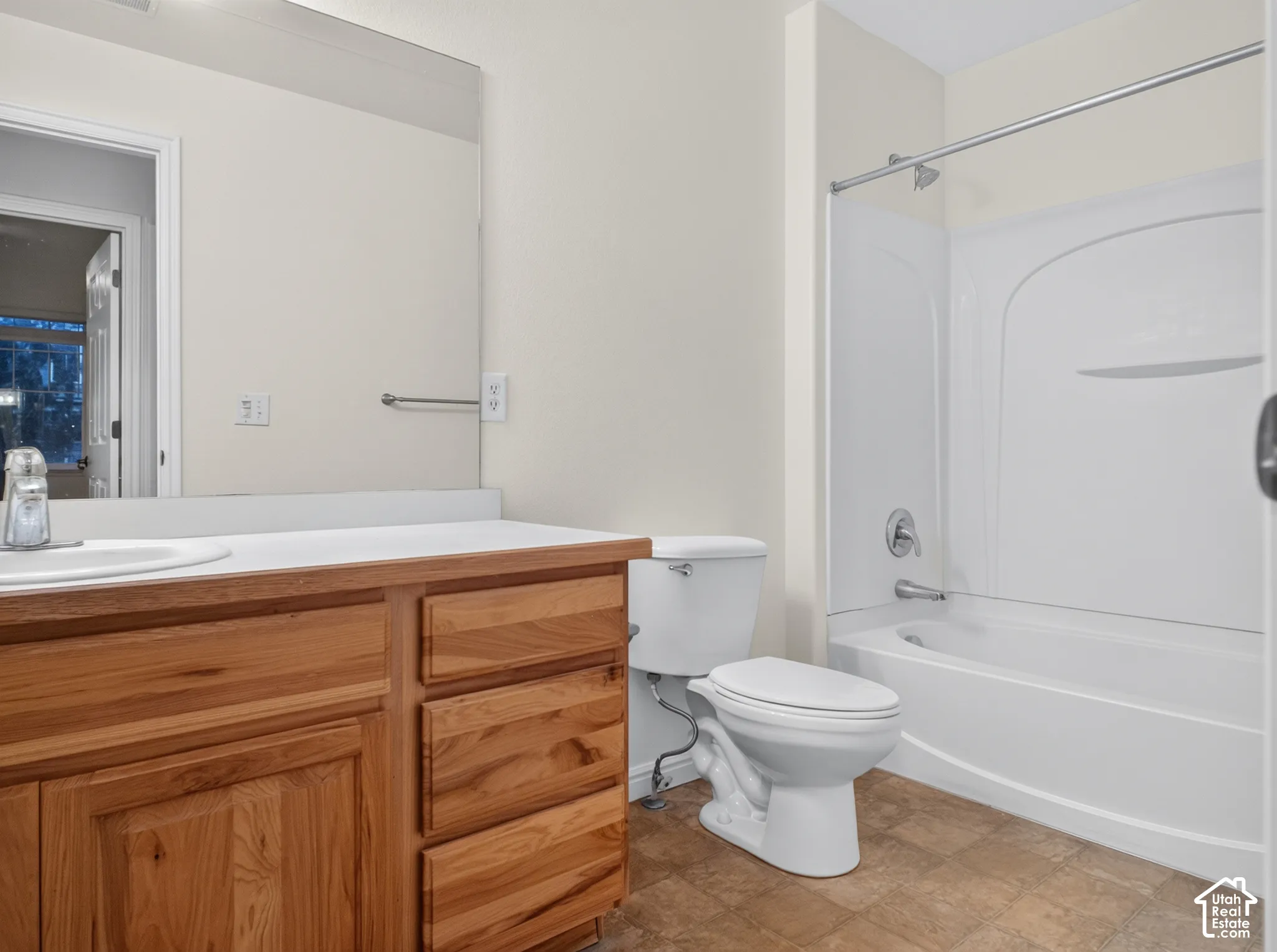 Wood-finish vanity with a white countertop and integrated sink, complete with a chrome faucet