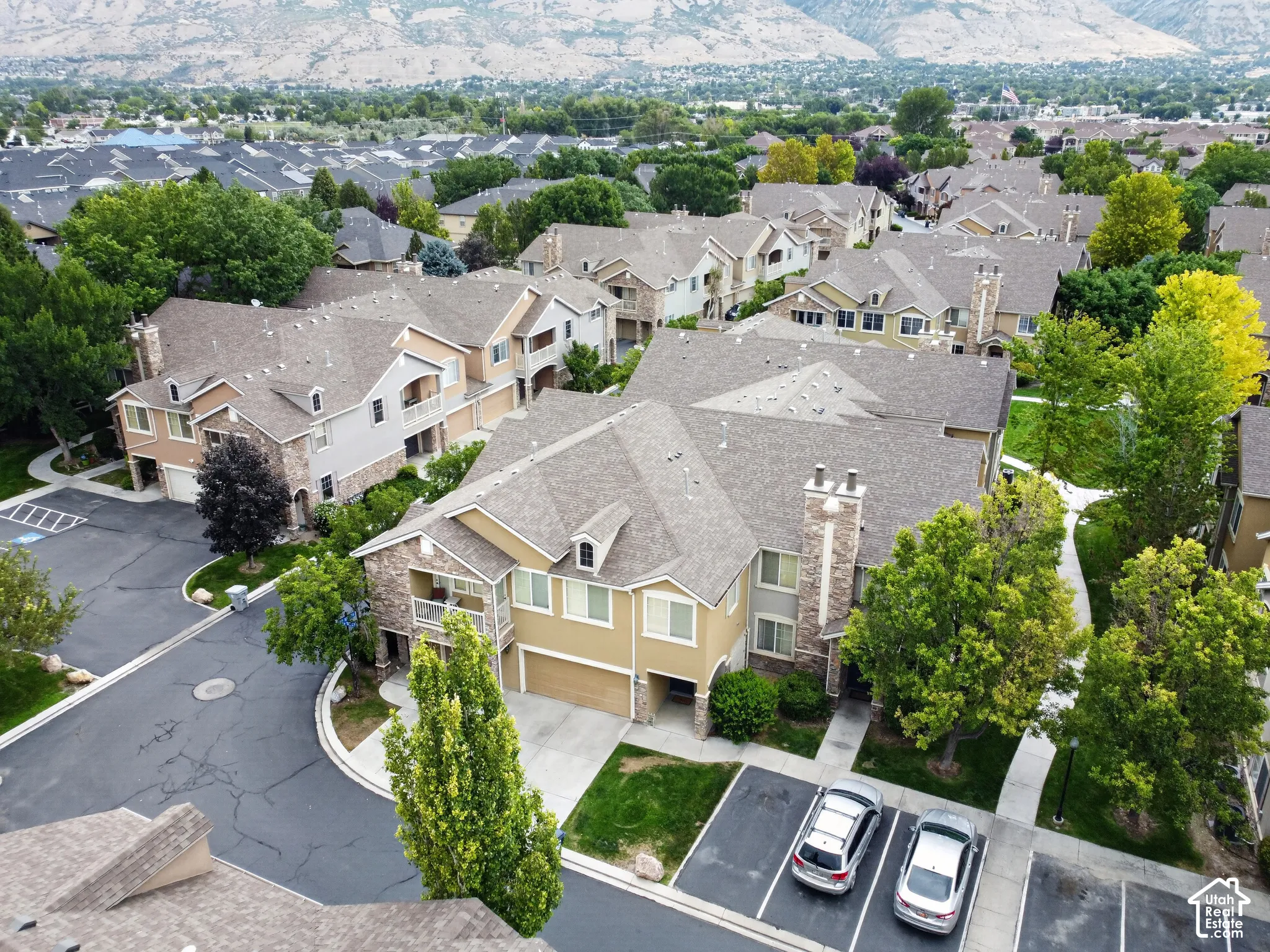 Townhome complex featuring multi-level units, individual garages, and covered balconies