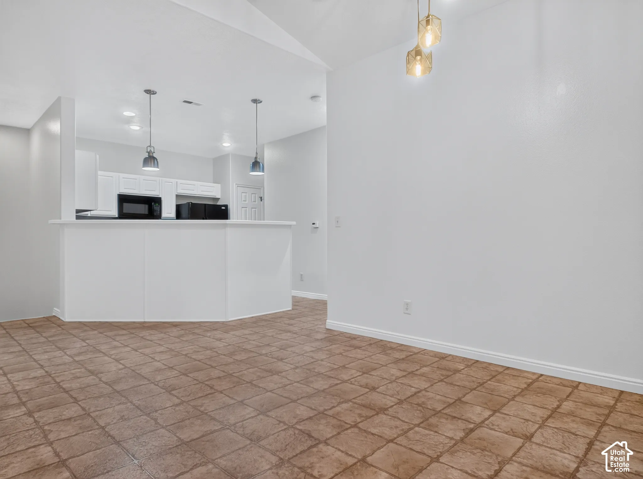 Kitchen featuring white cabinetry, pendant lighting, and a breakfast bar
