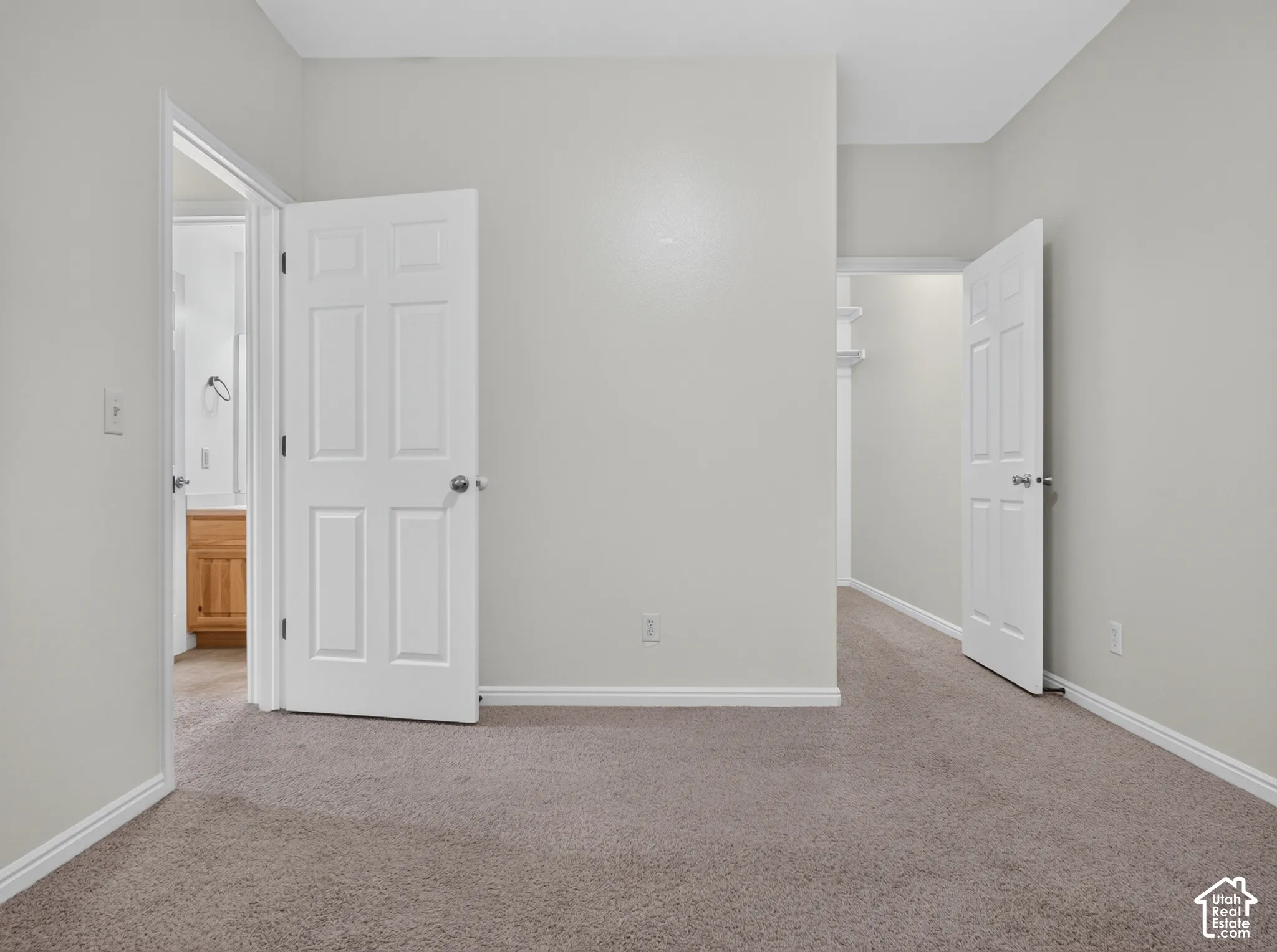 Textured carpeting throughout, light neutral wall color, white trim, and white paneled doors