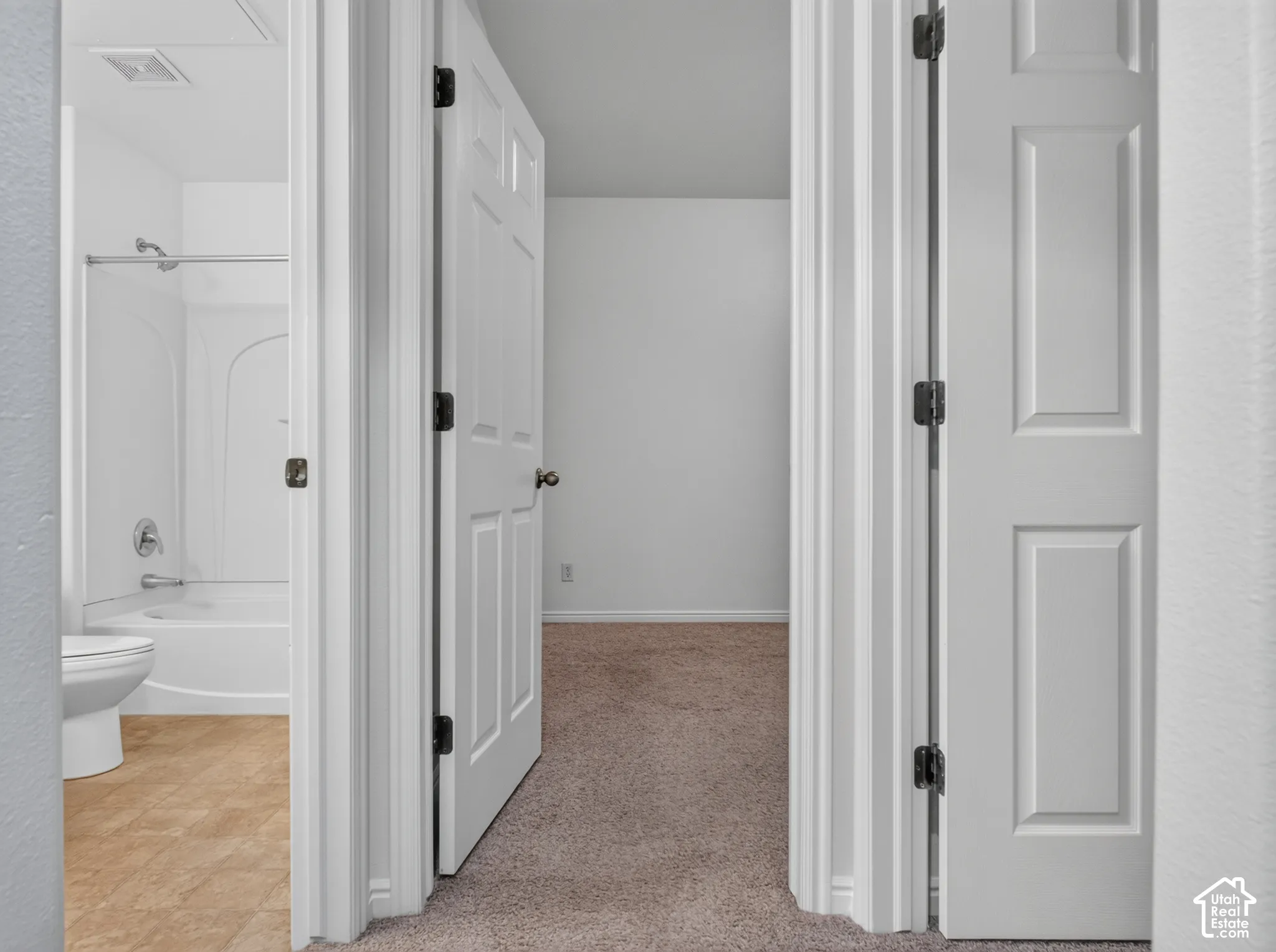 Full bath with a white shower/tub combination, toilet, and wood-finish flooring