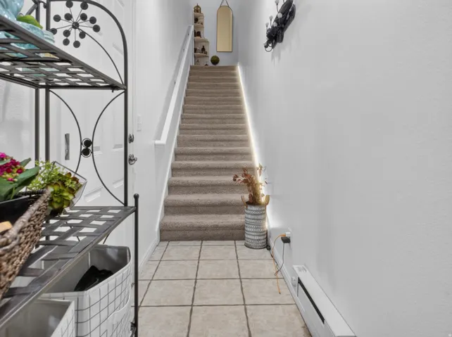 Staircase featuring carpeted treads and a white handrail