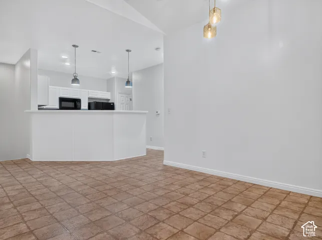 Kitchen featuring white cabinetry, pendant lighting, and a breakfast bar
