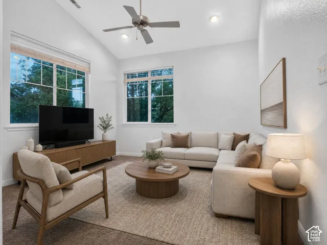 Vaulted ceiling with a ceiling fan, recessed lighting, large windows, and carpeted flooring