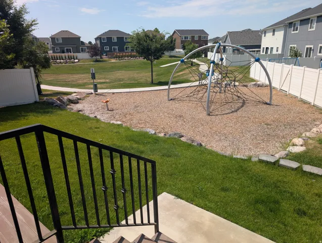 Outdoor recreational area featuring a spider web climber and wood chip surfacing