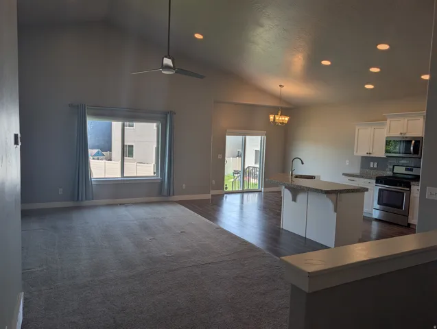 Open-concept living space featuring vaulted ceilings, recessed lighting, and a modern ceiling fan