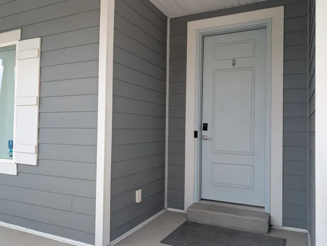 Entryway featuring a light blue paneled door with modern hardware, framed by white trim