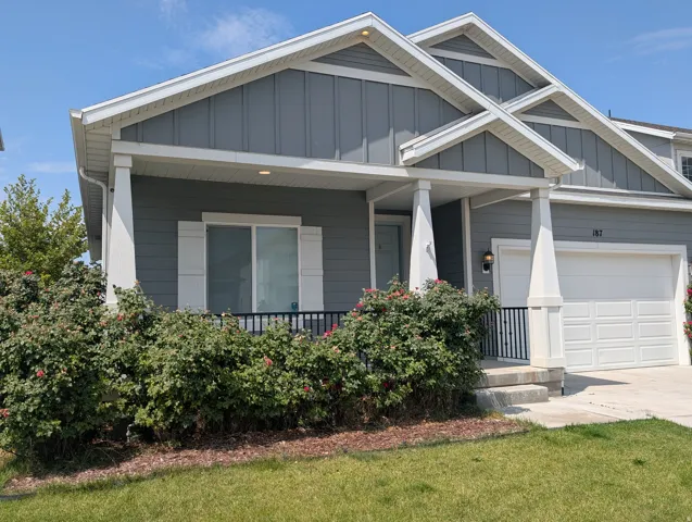Contemporary residence featuring grey siding with white trim accents and multiple gables