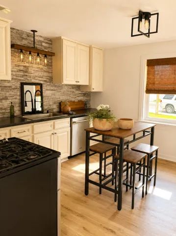 White cabinetry with dark countertops, stone-look backsplash, wood-finish flooring, and recessed lighting