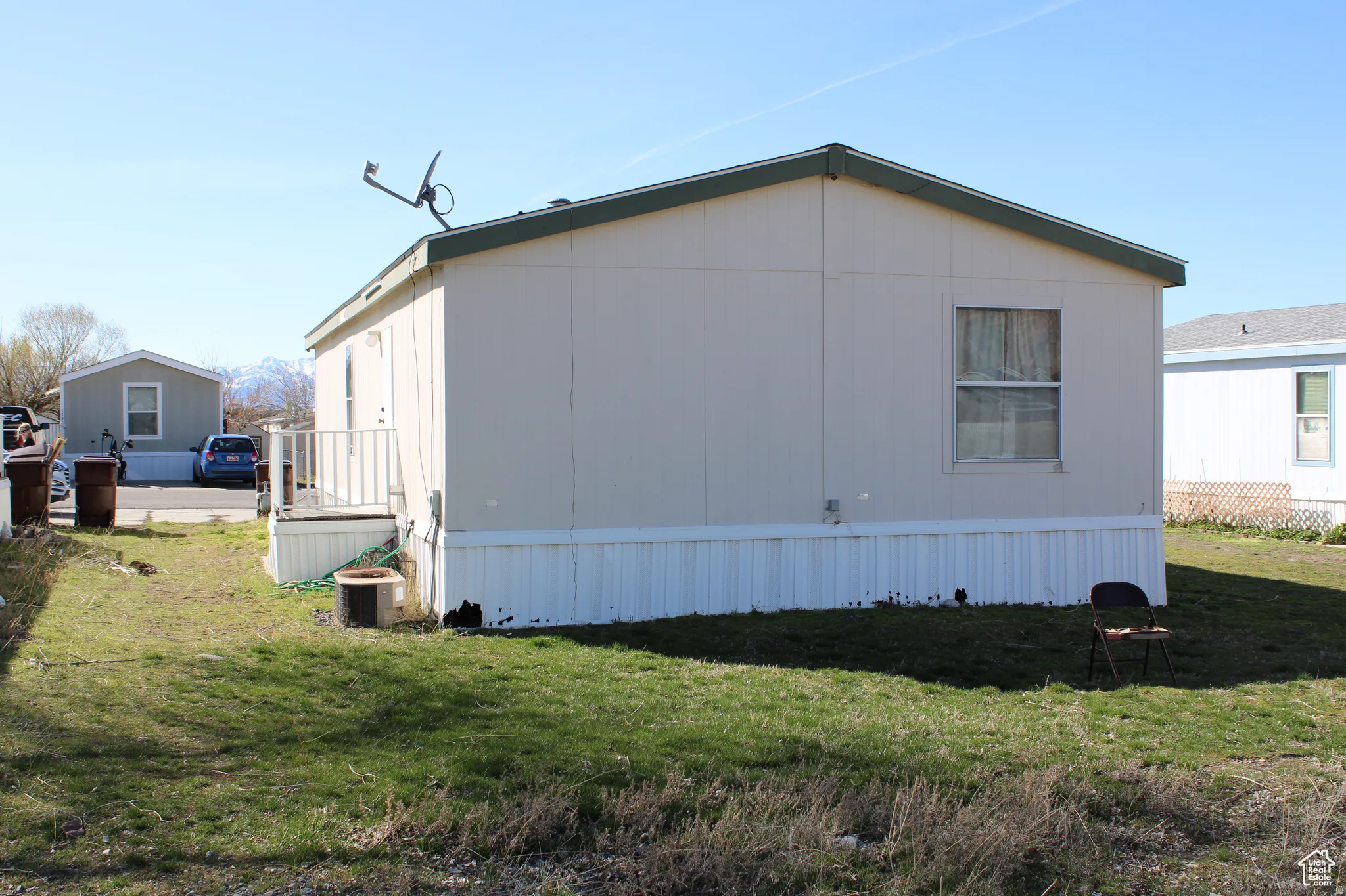Single-level property with light-colored siding and a dark green roof