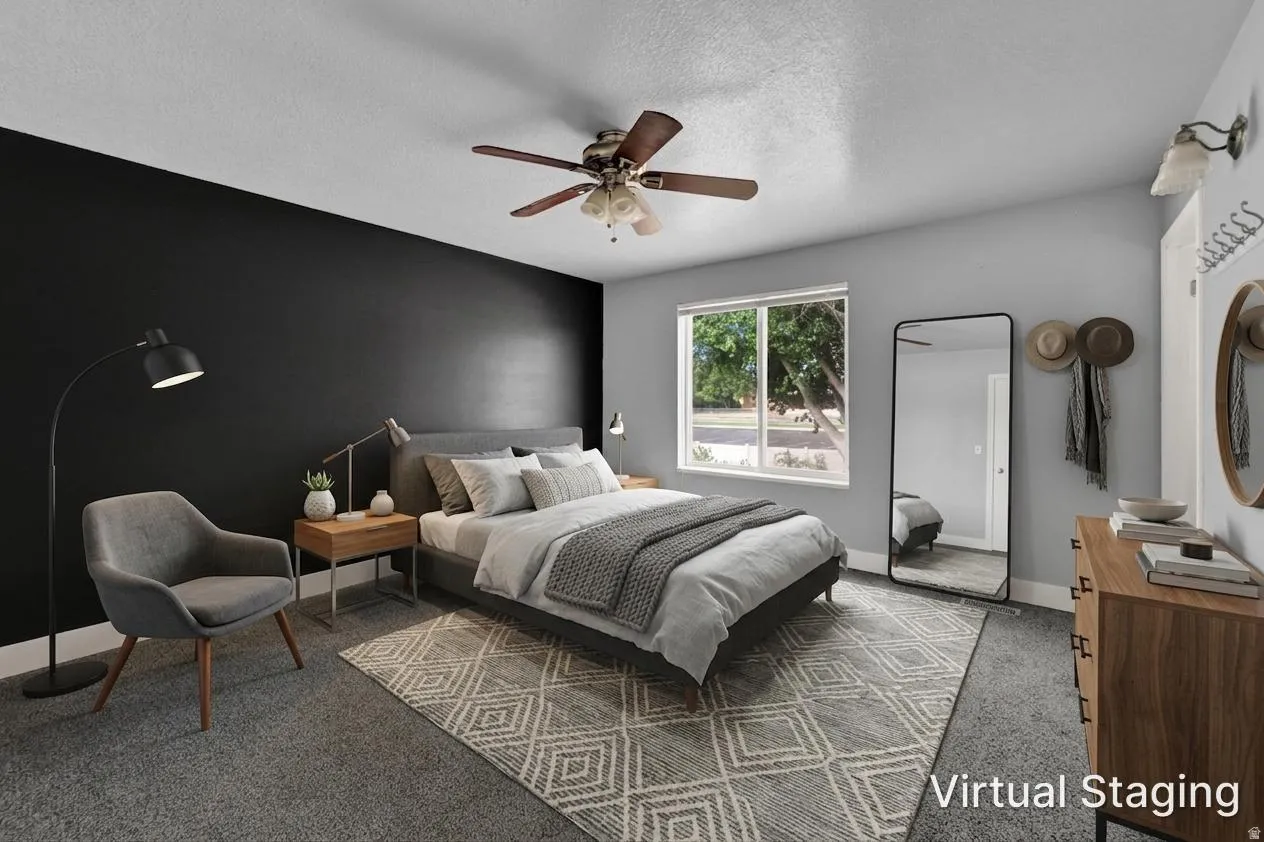 Carpeted bedroom featuring a ceiling fan with integrated lighting, a window with exterior views, and a contrasting accent wall