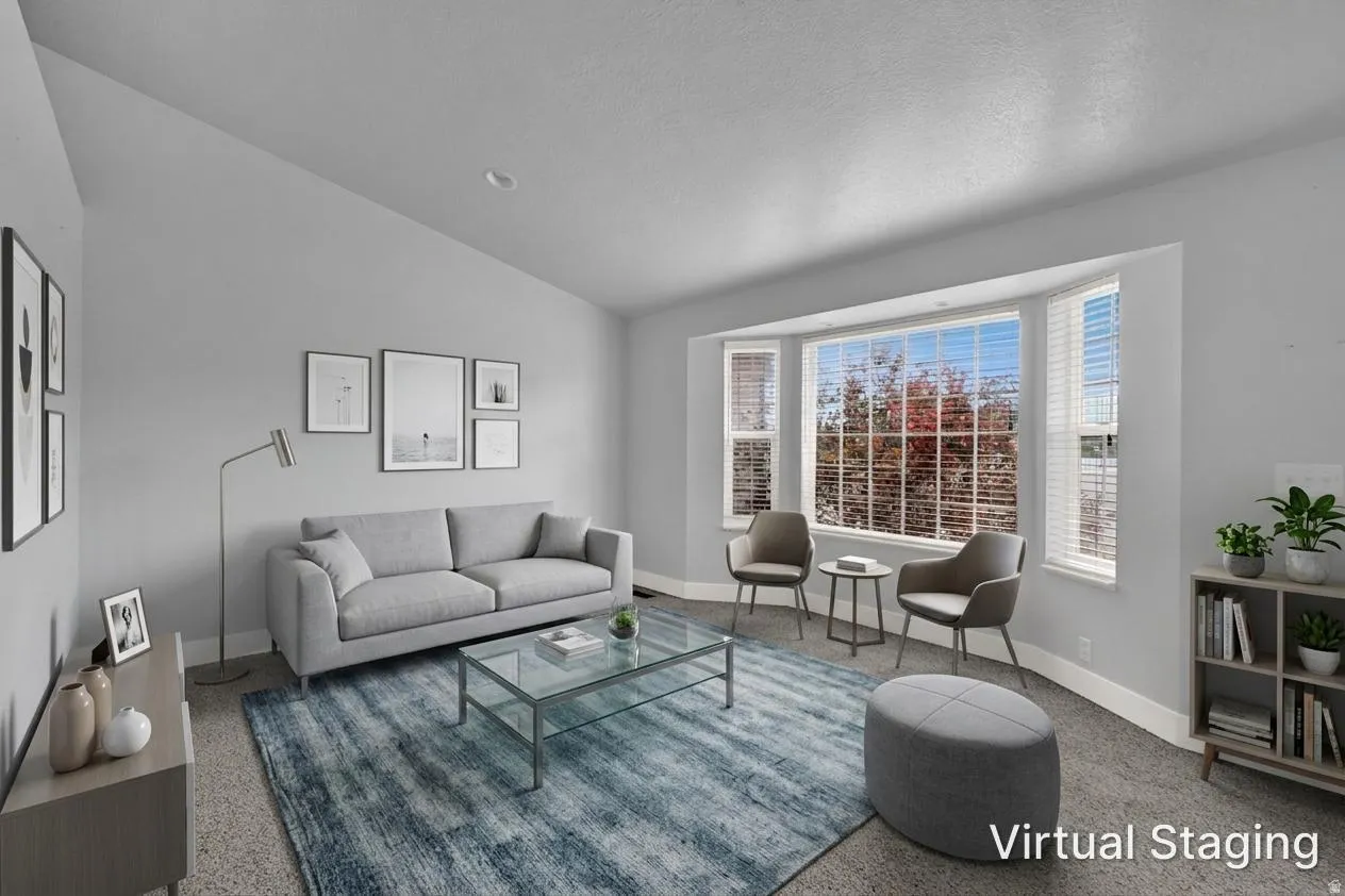 Living area featuring a prominent bay window, vaulted ceiling, and recessed lighting