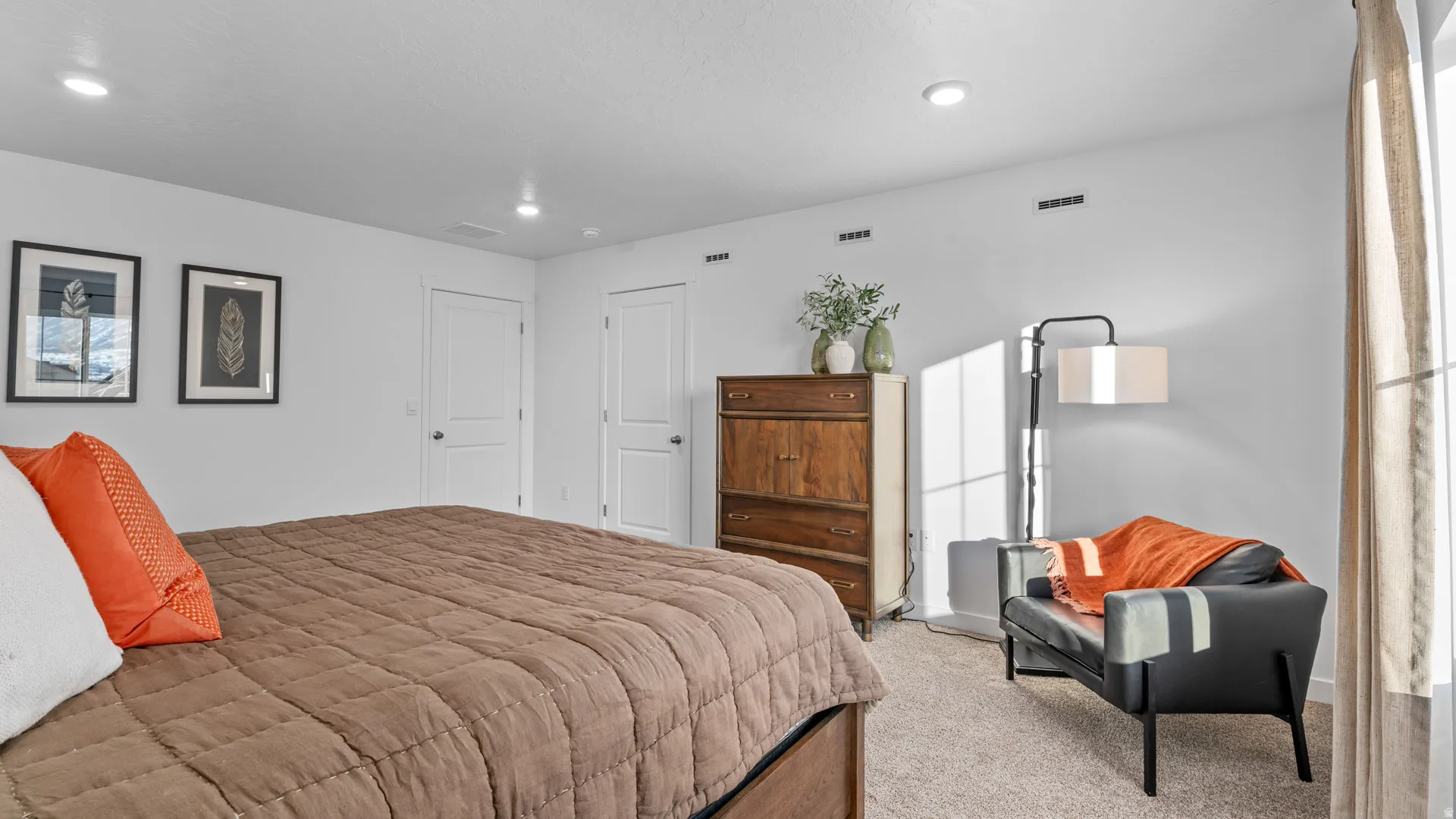 Wall-to-wall carpeting and white walls define this room featuring two white doors