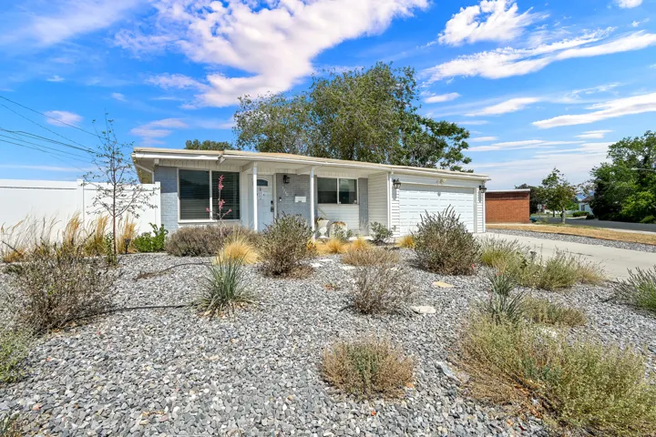 Modern bungalow exterior featuring a white garage door, a covered entryway, and a mixed material facade