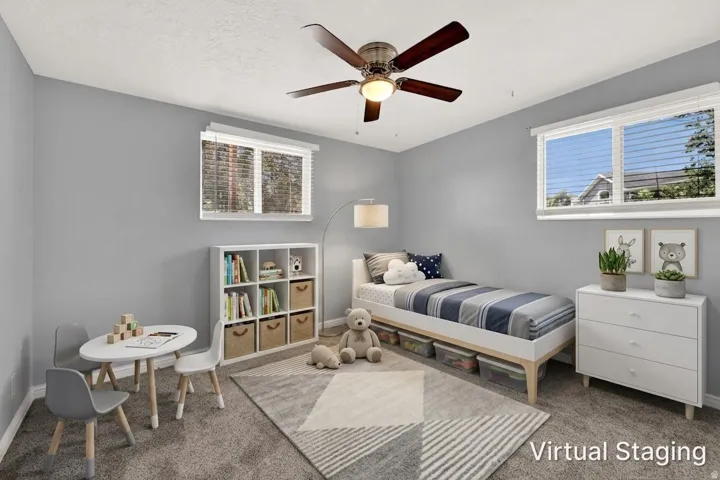 Light gray walls complement the carpeted flooring in this room featuring a ceiling fan with integrated lighting