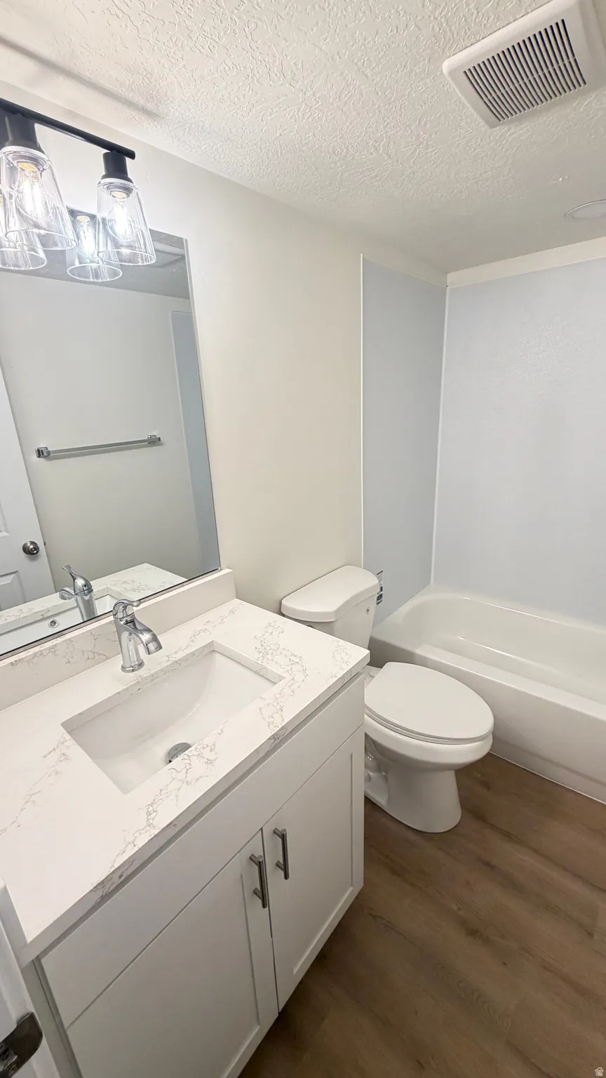 Bathroom featuring a white vanity with a light-colored countertop, an undermount sink, and a chrome faucet