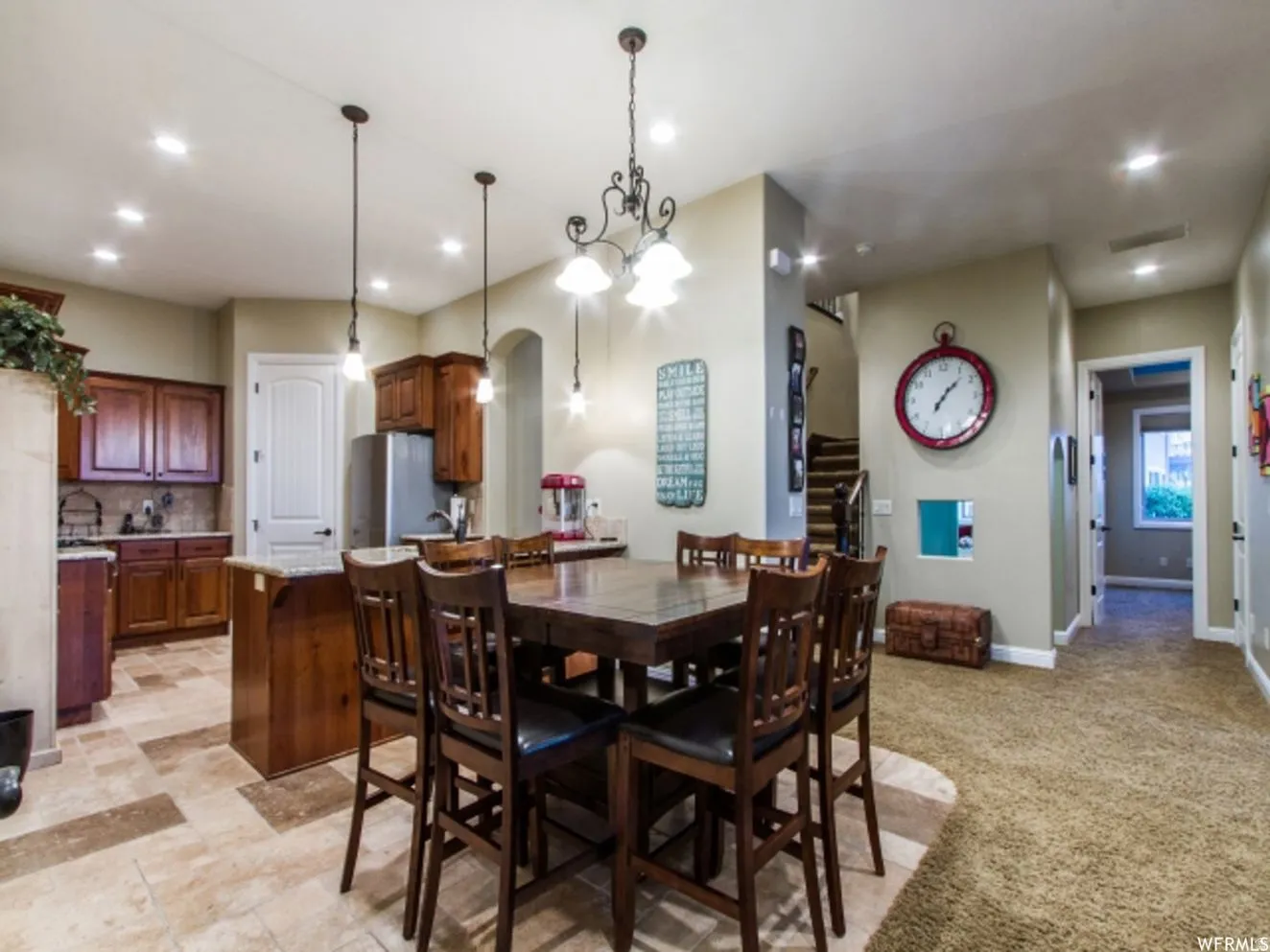 Kitchen and dining area featuring varied flooring, recessed lighting, and a chandelier