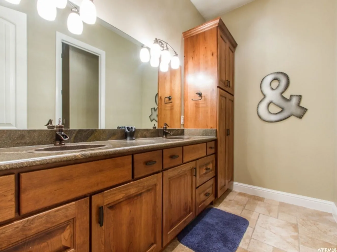 Double vanity with under-mount sinks, bronze-finish faucets, and granite-finish countertop