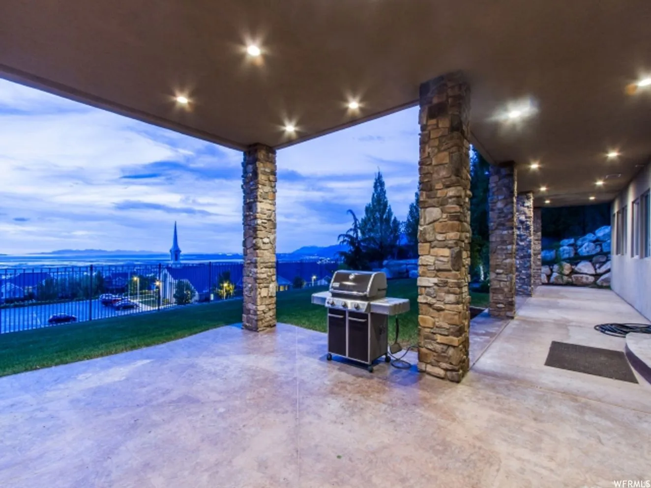 Covered patio featuring stone-clad columns and recessed lighting