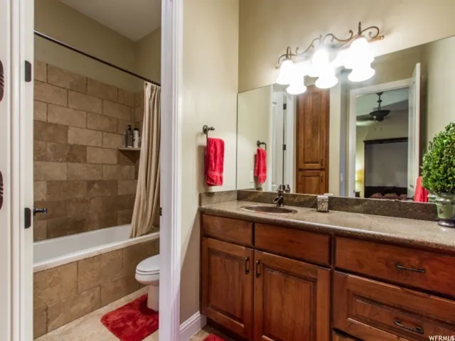 Bathroom vanity with a dark wood-finish cabinet, integrated sink, and stone-finish countertop