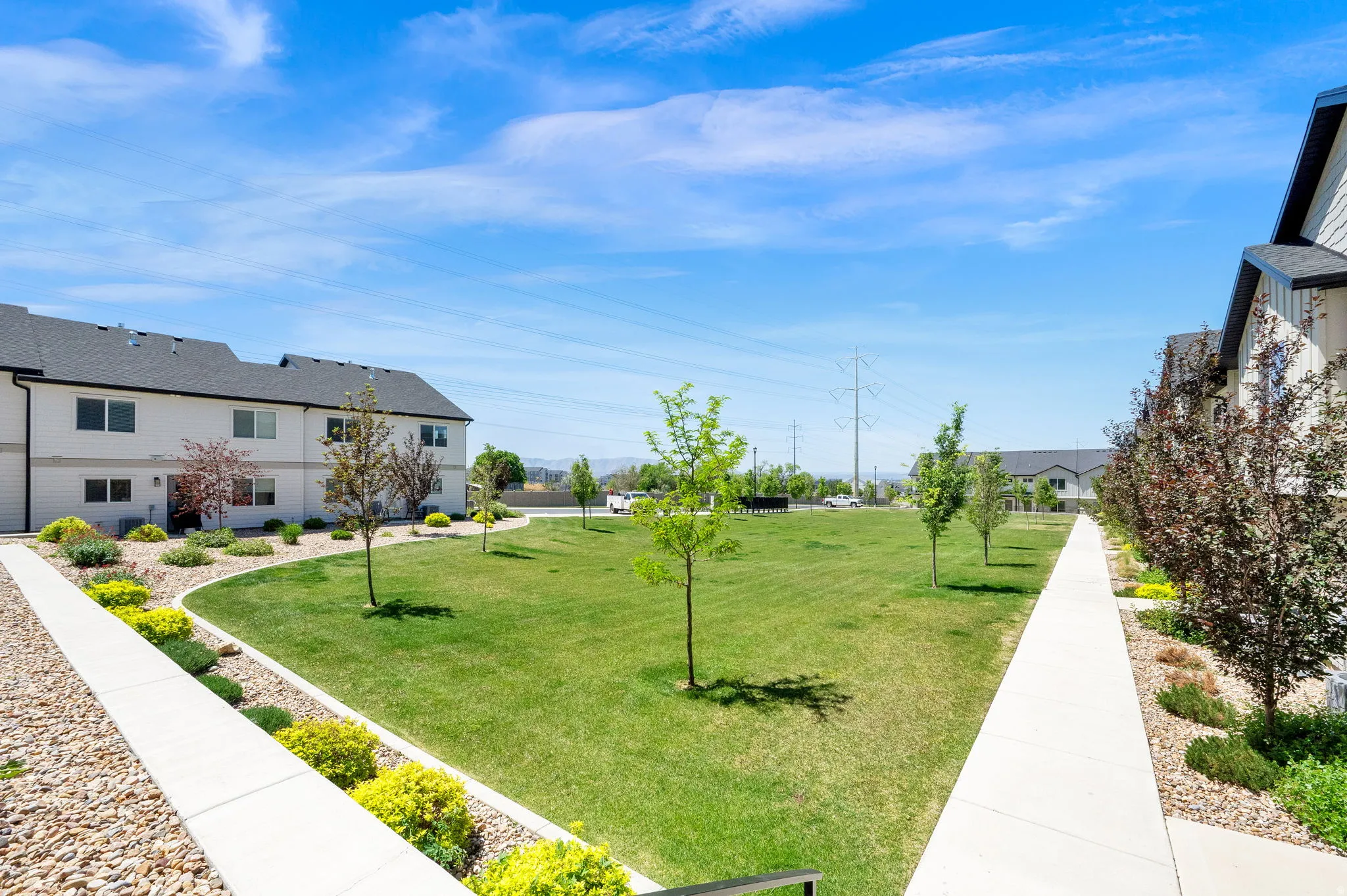Expansive central green space featuring mature trees and a manicured lawn