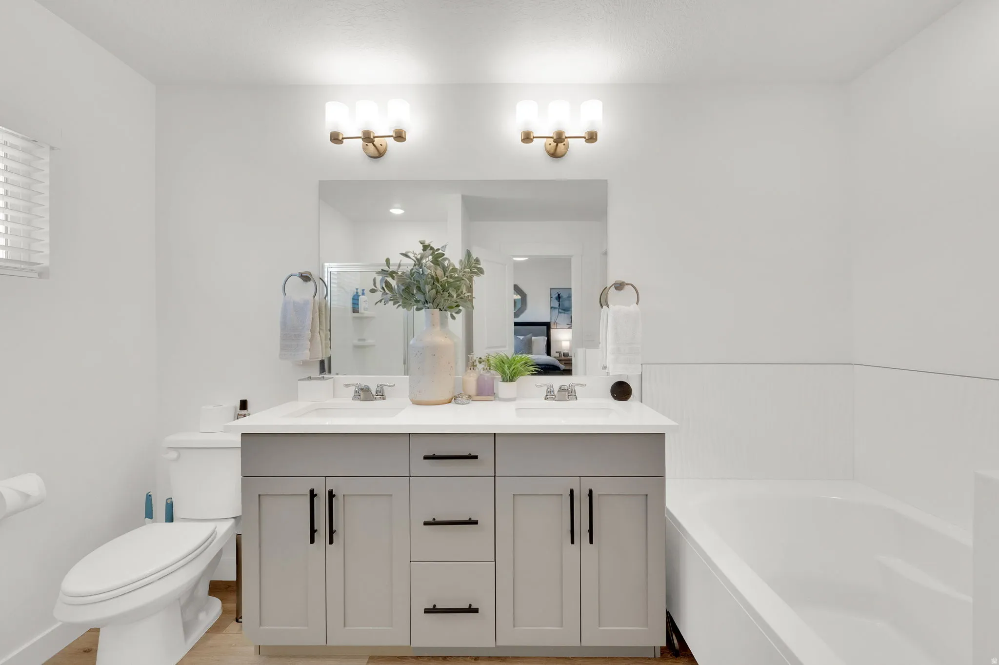 Dual vanity with light gray cabinetry, matte black hardware, and white countertops