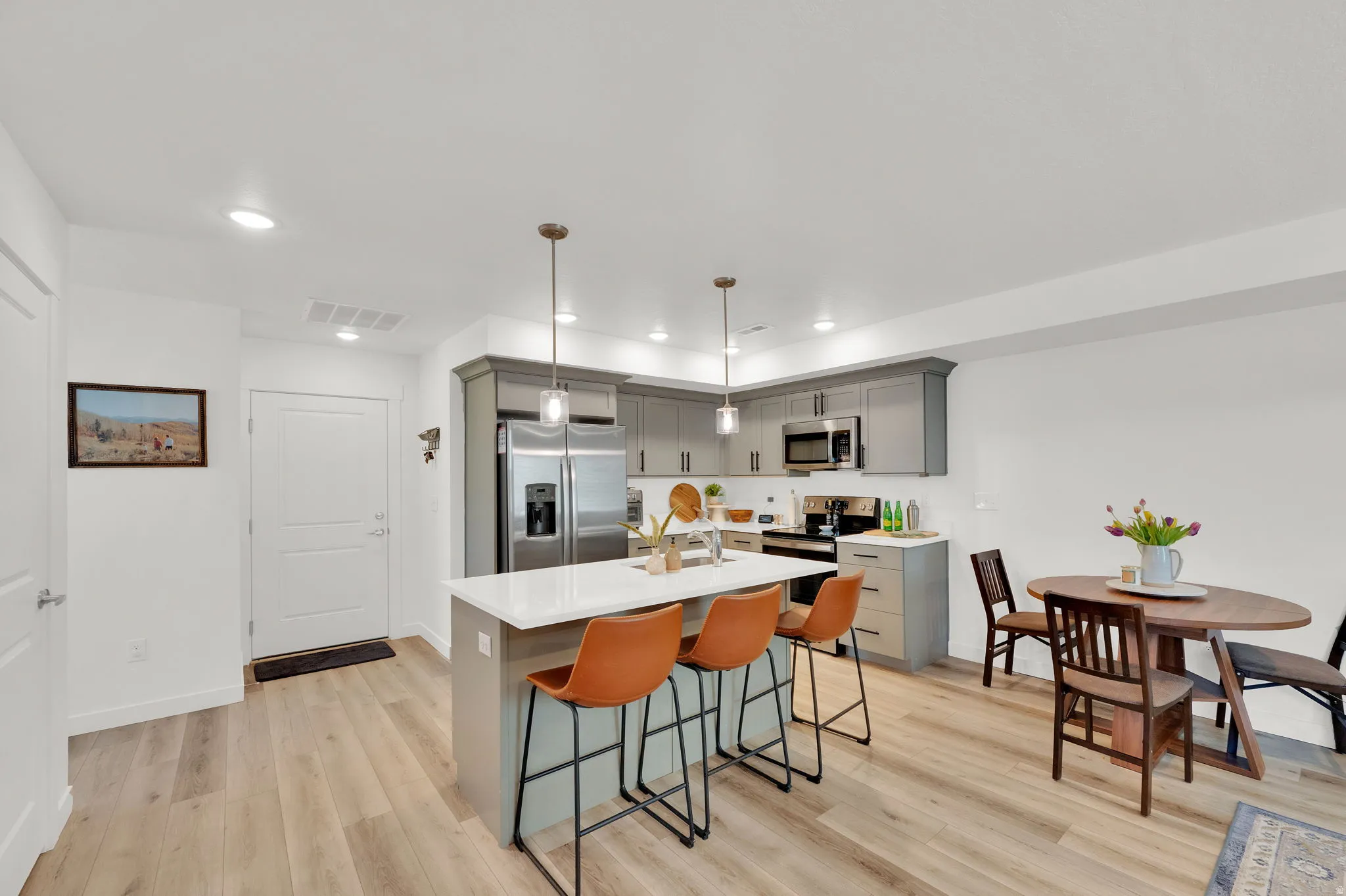 Kitchen featuring wood-finish flooring, recessed lighting, and a kitchen island with pendant lighting