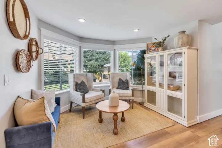 Recessed lighting illuminates a bay window area featuring a built-in display cabinet with glass-front doors