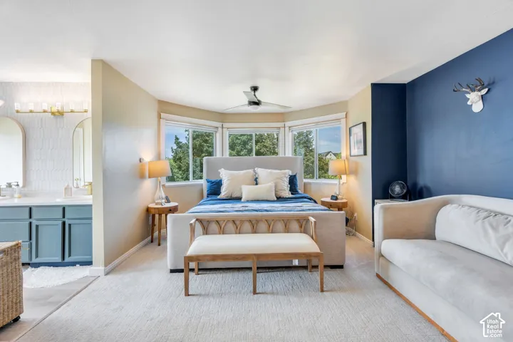 Spacious bedroom featuring multiple windows, ceiling fan, and carpeted flooring
